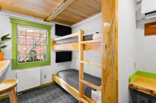 a room with bunk beds and a desk and a window at Downtown Camden Hotel in Camden