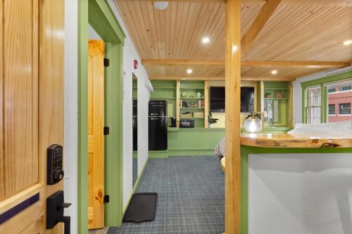 a kitchen with green walls and a wooden ceiling at Downtown Camden Hotel in Camden
