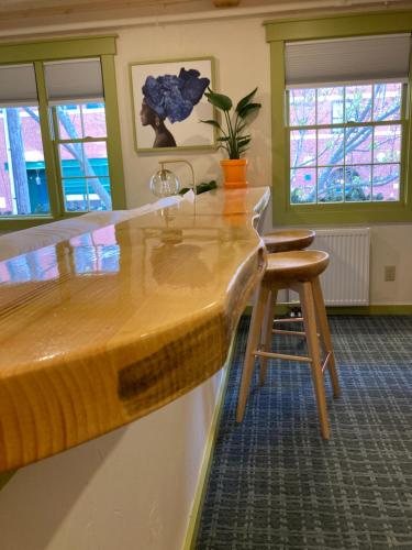 a kitchen with a counter and a stool and windows at Downtown Camden Hotel in Camden