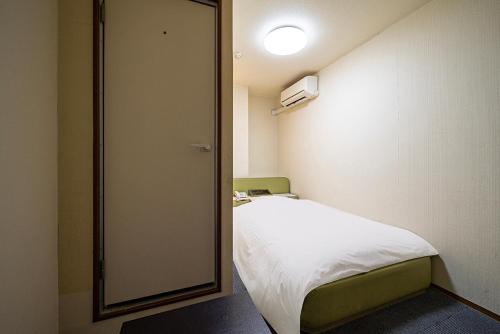 a small room with a bed and a mirror at Hotel Xenia Takinoyashiro in Kato