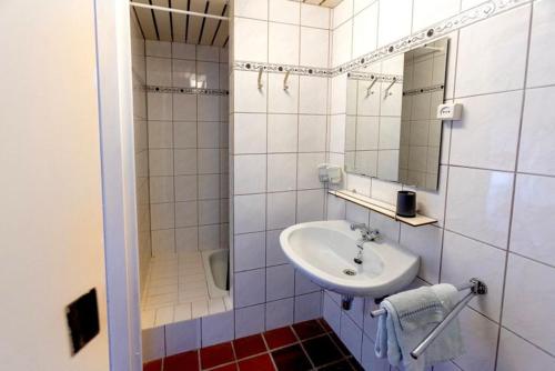a white bathroom with a sink and a mirror at Vakantie-studio in natuurgebied Hengelhoef in Houthalen-Helchteren