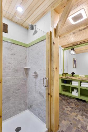 a shower in a bathroom with wooden ceilings at Downtown Camden Hotel in Camden