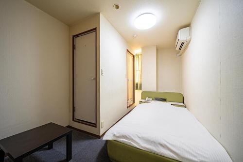 a small room with a bed and a table at Hotel Xenia Takinoyashiro in Kato