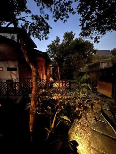 a tree sitting in front of a house at NATURAVE HOME - Tiny house with mountain view in Monteverde Costa Rica