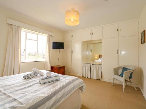 a bedroom with a bed and a window and a chair at Tegawelon in Harlech