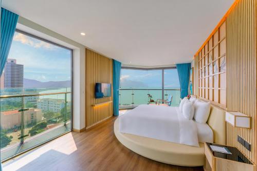 a bedroom with a large bed and a large window at Sala Quy Nhon Beach Hotel in Quy Nhon