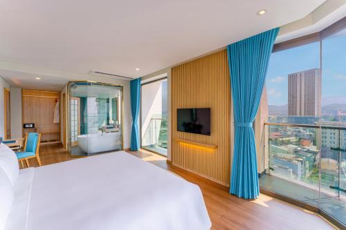 a bedroom with a large bed and a large window at Sala Quy Nhon Beach Hotel in Quy Nhon