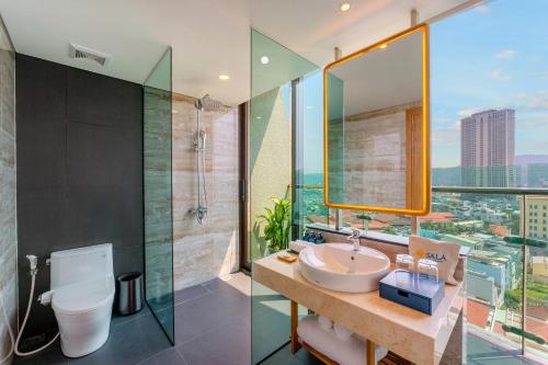 a bathroom with a sink and a shower at Sala Quy Nhon Beach Hotel in Quy Nhon