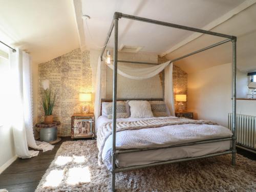 Bett in einem Zimmer mit Ziegelwand in der Unterkunft Coupling Cottage in Belper