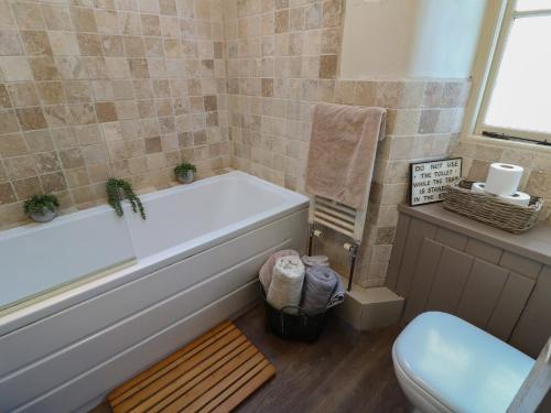 ein Badezimmer mit Badewanne und Toilette in der Unterkunft Coupling Cottage in Belper