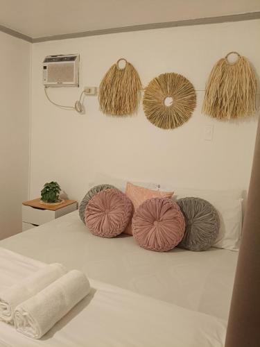 a bed with four different colored pillows on it at Ocean View Villa 1 in General Luna