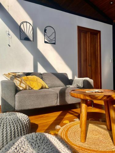 a living room with a couch and a table at NATURAVE HOME - Tiny house with mountain view in Monteverde Costa Rica