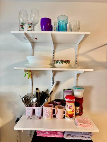 a shelf with bowls and utensils on it at Private Room with Shared Bathroom on the 1st Floor 10 Minutes Walk to University of Washington in Seattle