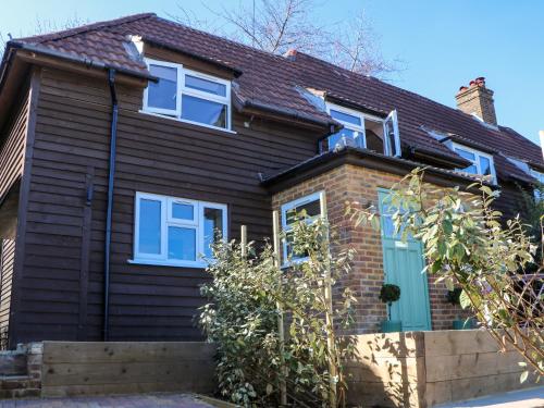 a house with blue windows and a brick at Hyrst Rise in Forest Row