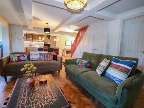 a living room with two couches and a table at Hyrst Rise in Forest Row