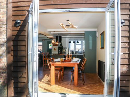 a dining room and kitchen with a table and chairs at Hyrst Rise in Forest Row