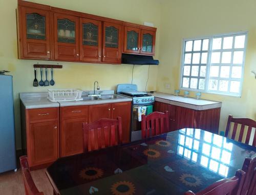 a kitchen with a table and a sink and a stove at Apartment in Finca Mayfran in Xul-Ha