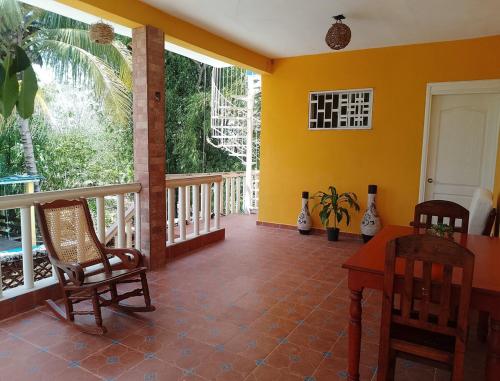 a room with a table and chairs on a porch at Apartment in Finca Mayfran in Xul-Ha