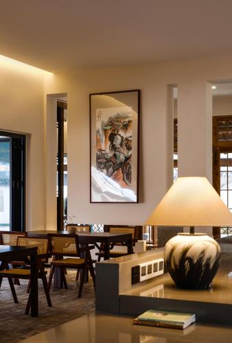 a living room with wooden tables and a large painting on the wall at Huangshan Yixian Pumanmanju Hotel in Huangshan