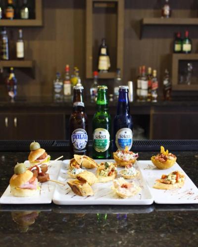 two plates of food and bottles of beer on a counter at Hesperia Maracay in Maracay