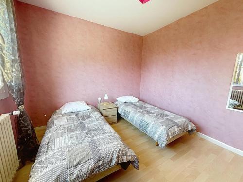 two beds in a room with pink walls at Confortable appartement proche du Port Guillaume pour 4 avec animaux admis - FR-1-465-125 in Dives-sur-Mer