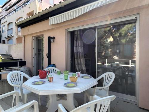 une table blanche et des chaises sur une terrasse dans l'établissement Charmant T2 mezzanine avec terrasse à Banyuls-sur-Mer - FR-1-225C-162, à Banyuls-sur-Mer