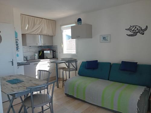 un salon avec un canapé et une table et une cuisine dans l'établissement Studio bord de plage Seignosse, loggia ouest - FR-1-239-1110, à Seignosse