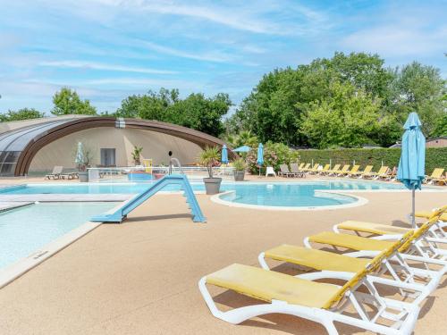 - une piscine avec des chaises longues et un toboggan dans l'établissement Chalet Confort à Biscarrosse - 6 Pers. - FR-1-319-594, à Biscarrosse