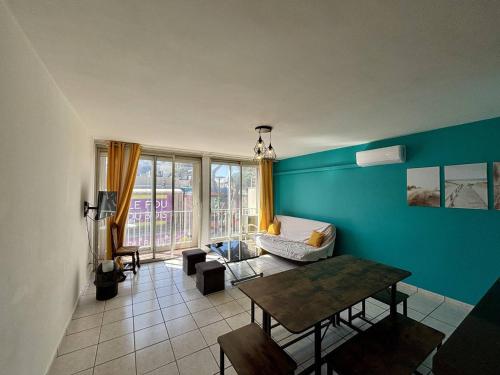 d'un salon avec des murs bleus et une table. dans l'établissement Appartement T3 à Argelès-Plage à 50m de la mer - FR-1-388-233, à Argelès-sur-Mer