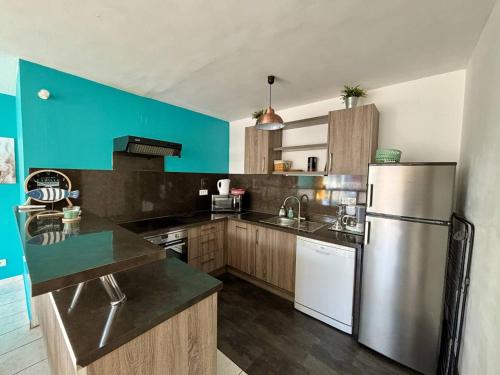 une cuisine avec un réfrigérateur en acier inoxydable et des armoires en bois dans l'établissement Appartement T3 à Argelès-Plage à 50m de la mer - FR-1-388-233, à Argelès-sur-Mer