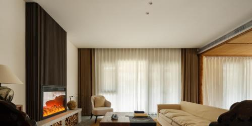 a living room with a couch and a tv at Huangshan Yixian Pumanmanju Hotel in Huangshan