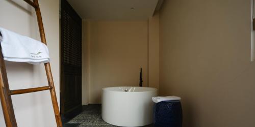 a room with a large white bucket and a ladder at Huangshan Yixian Pumanmanju Hotel in Huangshan