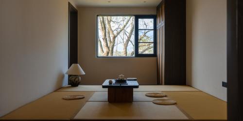 a room with a table and a window at Huangshan Yixian Pumanmanju Hotel in Huangshan