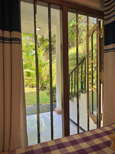 a room with a view of a balcony with sliding glass doors at Tobby Home Stay in Ahangama