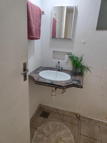 a bathroom with a sink and a mirror at Pousada Aleha Quarto Casal Rosé in Montes Claros