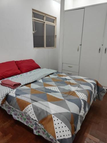 a bedroom with a bed with a colorful quilt on it at Pousada Aleha Quarto Casal Rosé in Montes Claros