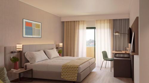 a bedroom with a bed and a desk and a television at Holiday Inn Algarve Albufeira by IHG in Albufeira