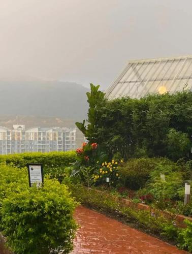 a garden in front of a large glass greenhouse at Campod Resort @ Cameron Highlands in Cameron Highlands