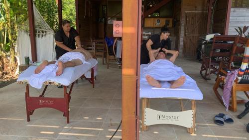 two men are laying on beds in a room at Uvita Oasis Retreat with Villa Cabins and Apartment in Uvita
