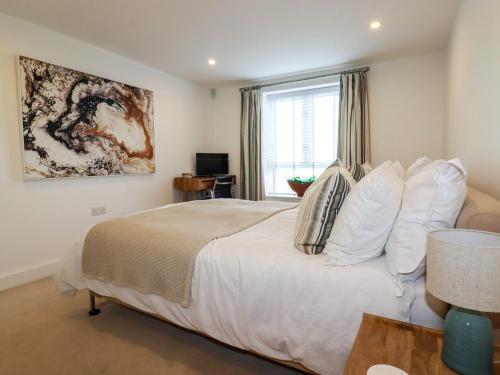 a bedroom with a bed with white pillows and a window at 4 Ocean Gate in Newquay