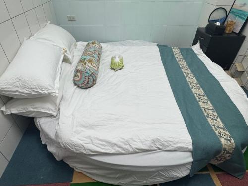 a bed with two pillows and a cat sitting on it at Lukang Hung-shiu Homestay in Lugang