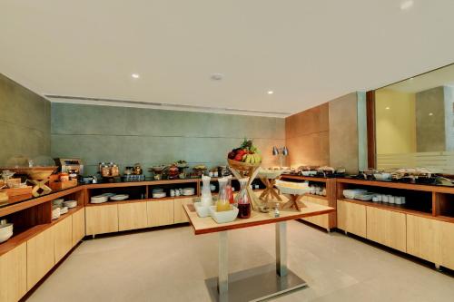 The Fern Residency Woodland, Pune, Series by Marriott في بيون: مطبخ كبير مع دواليب خشبية وطاولة