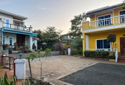 a yellow house with a balcony and a yard at Sokha Veary Ratanak Homestay in Banlung