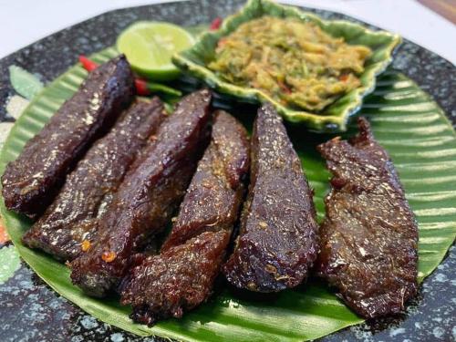 a green plate with three pieces of food on it at Sokha Veary Ratanak Homestay in Banlung