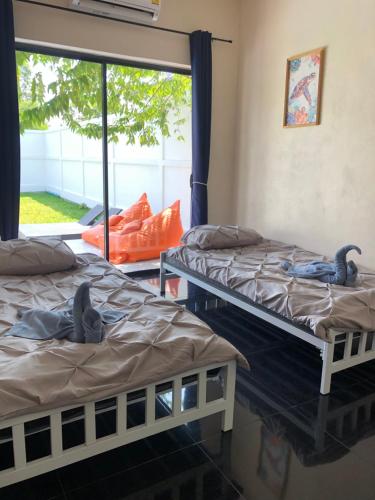 two beds in a room with two birds on them at Villa Koh Mzé, 2 bedrooms with peaceful pool in Hua Thanon Beach