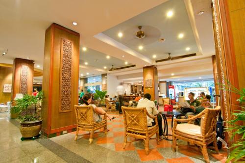 un grupo de personas sentadas en sillas en un restaurante en Golden Beach Hotel Pattaya, en Pattaya central