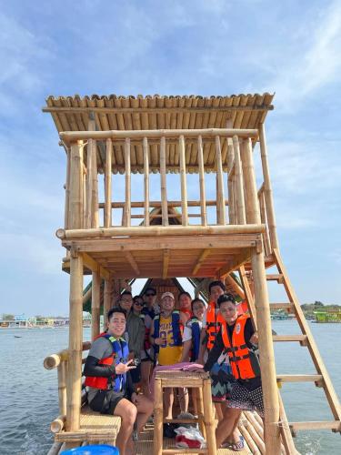 a group of people sitting in a wooden structure on the water at Balsa Republic in Calatagan
