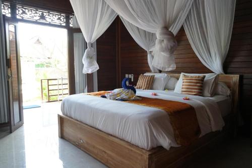 una camera da letto con un grande letto a baldacchino di Karang Buncing Lembongan a Nusa Lembongan
