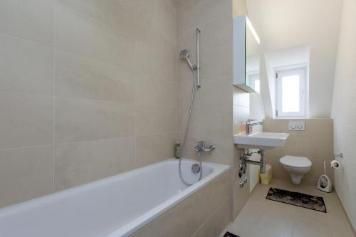 a white bathroom with a tub and a sink at KAYA Zurich Apartment 5A - Downtown 2-BR Deluxe Loft Apt in Zürich