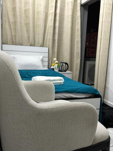 a bedroom with a bed with a chair and a couch at Abu Dhabi Phenomenal in Abu Dhabi